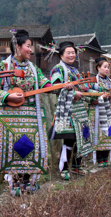 Image: Ethnic Dong women wearing traditional costumes, hold \"pipas\", a traditional instrument