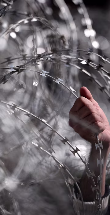 Image: Migrant holding wire