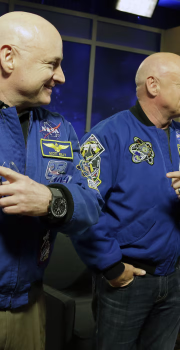 NASA astronaut Scott Kelly, left, and his identical twin Mark, a retired NASA astronaut, stand together before a news conference in Houston. Scott Kelly set a U.S. record with his 340-day mission to the International Space Station. 
