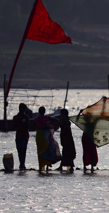Image: Indian women dry their saris after taking a dip at Sangam