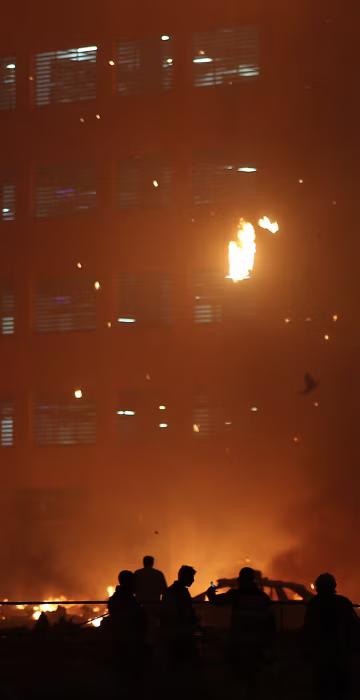 Image: Debris falls from a high-rise building as a fire spreads up the side of the building in Ajman