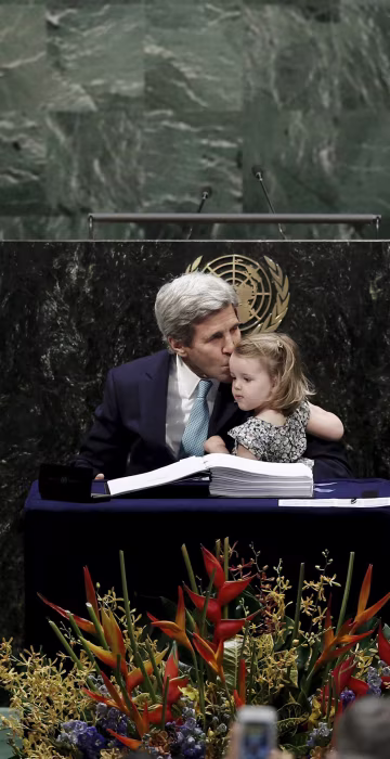 Image: U.S. Secretary of State Kerry holds his granddaughter as he signs the Paris Agreement on climate change at United Nations Headquarters in New York