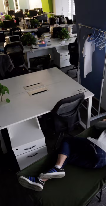 Image: The Wider Image: Working, eating and sleeping at the office