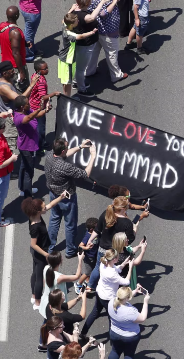 Image: Well-wishers touch the hearse carrying the remains of Muhammad Ali during the funeral procession in Louisville