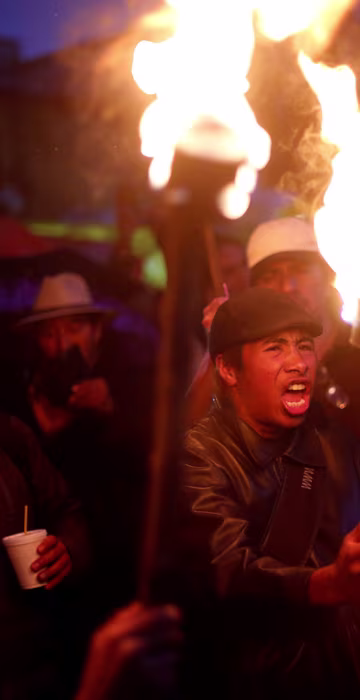 Image: A protester from the CNTE teachers' union holds a torch as he yells during a march following clashes in southern Mexico over the weekend between police and members of CNTE, in Mexico City