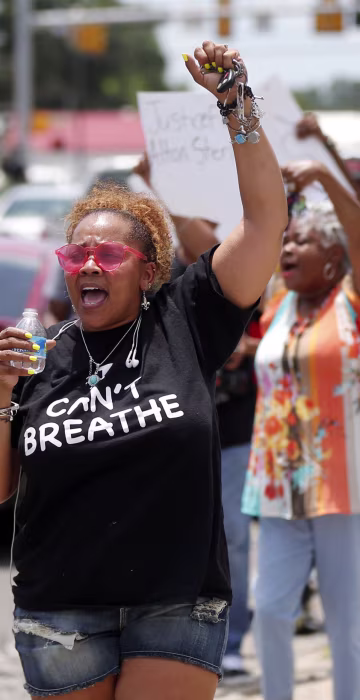 Image: People march outside the Triple S convenience store in Baton Rouge