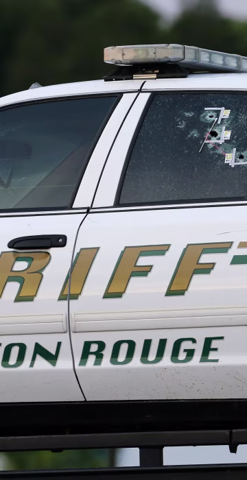 Image: An East Baton Rouge Sheriff vehicle is seen with bullet holes in its windows near the scene where police officers were shot, in Baton Rouge