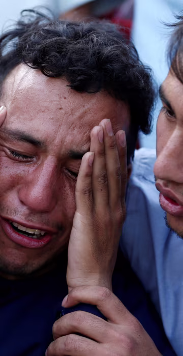Image: An Afghan man weeps outside a hospital after a suicide attack in Kabul, Afghanistan