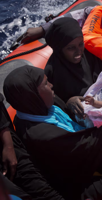 Image: Migrant women from Nigeria, one of them holding a baby, are rescued by emergency teams