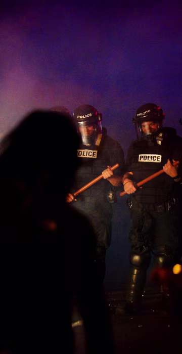 Image: Officers stand in formation in front of protesters in Charlotte