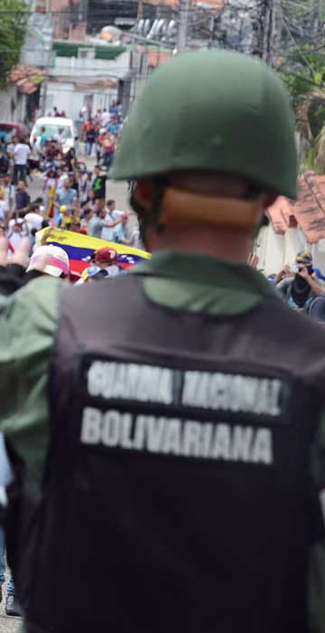 Image: Demonstrators shout slogans in front of Venezuelan National Guard members during a rally demanding a referendum to remove Venezuela's President Maduro in San Cristobal