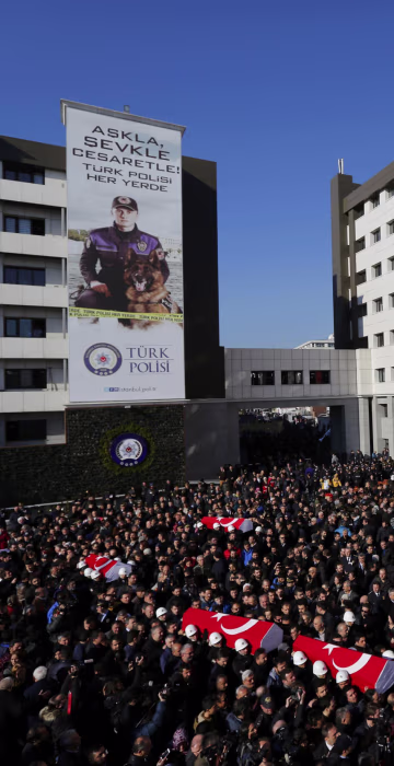 Image: People carry the flag-draped coffins of police officers killed in Saturday's blasts in Istanbul