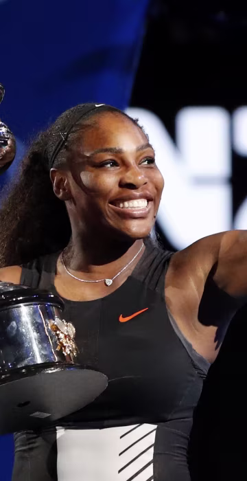 Image: United States' Serena Williams holds her trophy after defeating her sister Venus