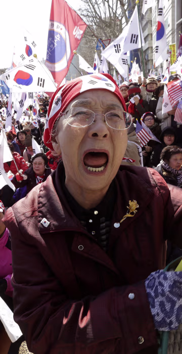 Image: A supporter of the South Korean president cries during a rally opposing her impeachment.