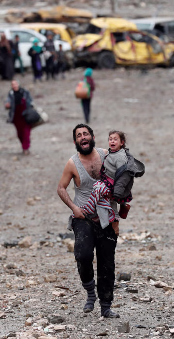 Image: A man cries as he carries his daughter while walking from an Islamic State-controlled part of Mosul towards Iraqi special forces soldiers during a battle in Mosul