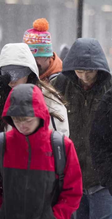 Image: A tourist group walks through the snow and wintry mix in New York
