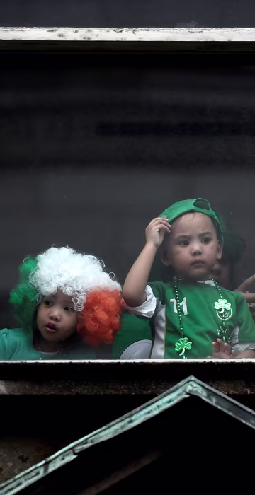 Image: Children watch the St. Patrick's day parade from a window in Dublin