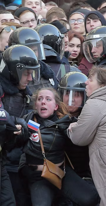 Image: Russian riot policemen detain a demonstrator.