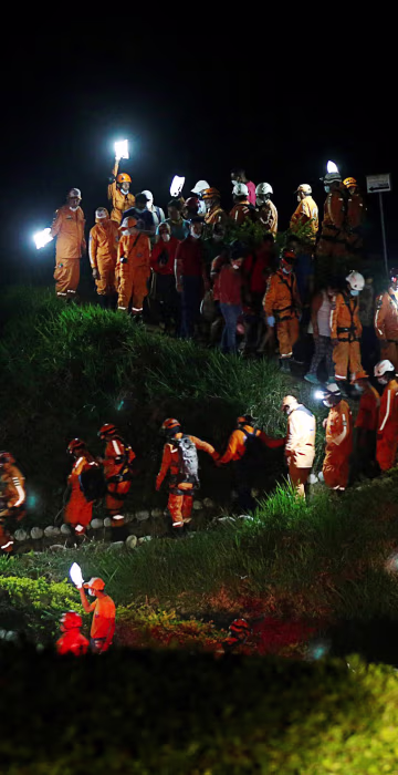 Image: Rescue members walk during the burial of a companion who died after flooding and mudslides caused by heavy rains lead several rivers to overflow, pushing sediment and rocks into buildings and roads, in Mocoa