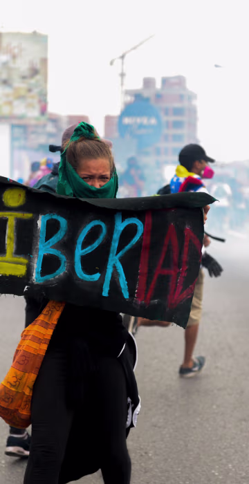 Image: A woman holds a sign stating Libertad during the opposition clash with riot police in Venezuela