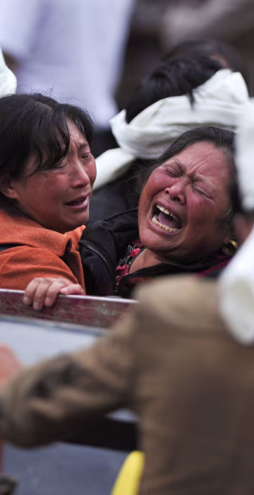 Image: Women become emotional at the site of the landslide on June 25.