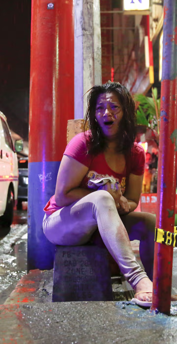 Image: A woman cries after her husband was shot dead by unidentified gunmen riding motorcycles in Manila