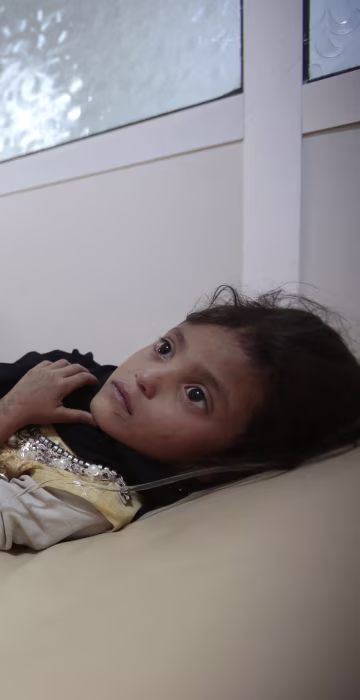 Image: A girl is treated for suspected cholera infection at a hospital in Sanaa