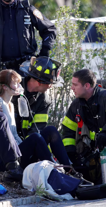 Image: A woman is aided by first responders after sustaining injury on a bike path in lower Manhattan in New York