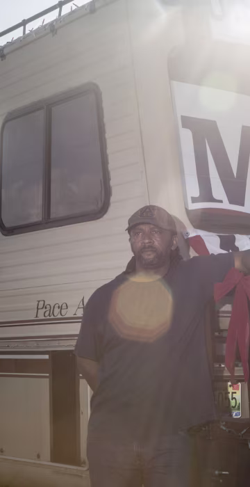 Image: Romeo Ryan stands for a portrait with his RV while stopped along the side of the road in Daphne, Alabama on his way to the Moore rally in Fairhope.