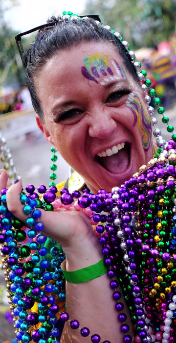Karen Price shows off her catch of beads from the The Krewe of Thoth parade during Mardi Gras celebrations in New Orleans on Feb. 11, 2018.