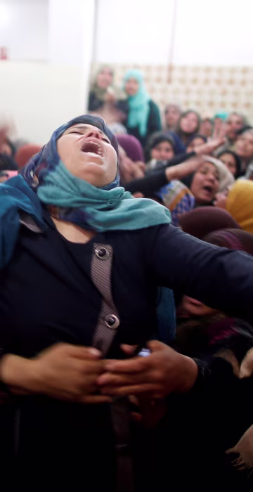 Mourners hold back a relative of Palestinian Hamdan Abu Amshah, who was killed along Israel border with Gaza, during his funeral in Beit Hanoun, in the northern Gaza Strip on March 31.