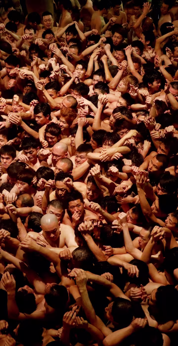 Image: Men dressed in loincloths prepare to snatch a wooden stick called \"shingi\" tossed by the priest during a naked festival at Saidaiji Temple in Okayama