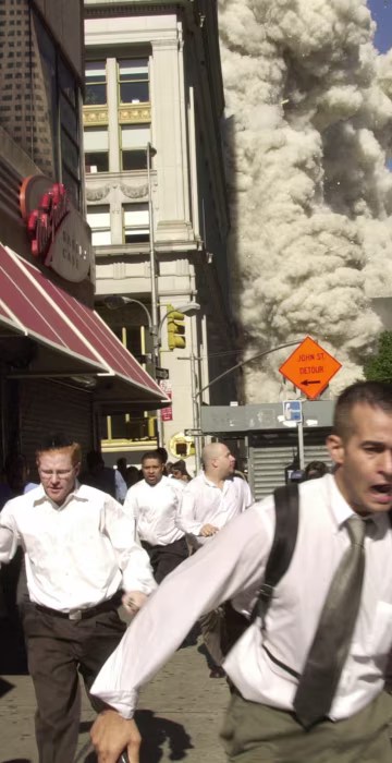 Smoke and debris fill the streets as pedestrians run for cover after the collapse of the south tower. What started as a bright sunny day turned to darkness. "Suddenly the top of [the tower] just shattered into tens of thousands of pieces," said Steve Johnson of msnbc.com. "You could see the whole thing just disappeared. Then the smoke came up. The cops started yelling, 'Get back! Run! Get Away!' I ran inside a hotel, and it went black outside because of the dust."