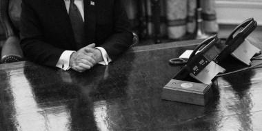 Image: Then-President Donald Trump is reflected on the Resolute Desk in the Oval Office at the White House in 2019.