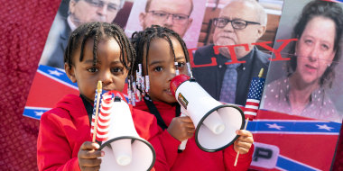 Image: Three year-old Curtis Hayes III and four year-old T'Kyrra Terrell use megaphones outside the Glynn County Courthouse as the jury deliberates in the trial of the killers of Ahmaud Arbery.