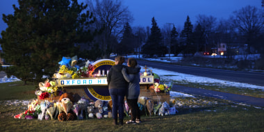 People visit a makeshift memorial outside of Oxford High School in Oxford, Mich on Dec. 1, 2021 .
