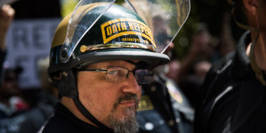 Image: A man wearing a helmet that reads,\"Oath Keepers\".