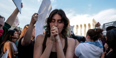Image: A girl praying amidst protestors.