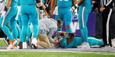 Image: Miami Dolphins quarterback Tua Tagovailoa is attended by medical staff.