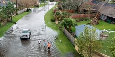 Image: People walk along a flooded street in the Spring Meadow subdivision in LaPlace, La., after Hurricane Ida moved through Monday, Aug. 30, 2021. Hard-hit LaPlace is squeezed between the Mississippi River and Lake Pontchartrain.