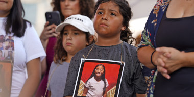 A young protester wears an image of Tess Mata, who was killed in the Uvalde school shootings, outside the NRA meeting.