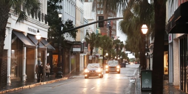 Cars drive through a nearly-deserted Charleston historic district