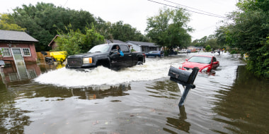 A car drives through high water from from Hurricane Ian