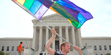 A person waves a rainbow flag in support of gay marriage outside of the Supreme Court