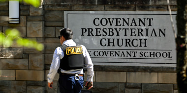 Image: A police officer walks by an entrance to The Covenant School after a shooting in Nashville, Tenn. on March 27, 2023.
