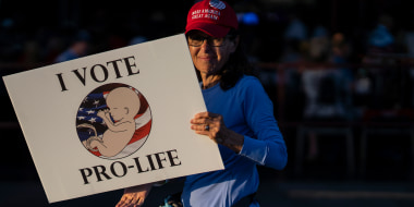 A woman holds anti-abortion sign before Florida Gov. Ron DeSantis  speaks to supporters in Clearwater, Fla. in 2022.