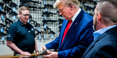 Former President Donald Trump examines a customized Glock pistol decorated with his name and likeness during a visit the Palmetto State Armory in Summerville, S.C., on Sept. 25, 2023.