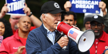 President Joe Biden speaks into a megaphone on a UAW picket line