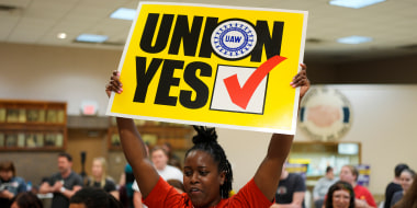 A woman holds a sign that says "Union Yes"