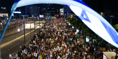 Demonstrators lift placards and flags during a protest in Tel Aviv, Israel.